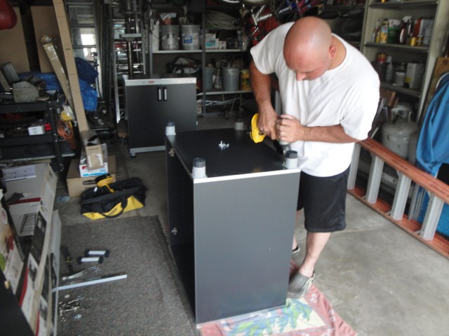 Man working on garage makeover with drill.