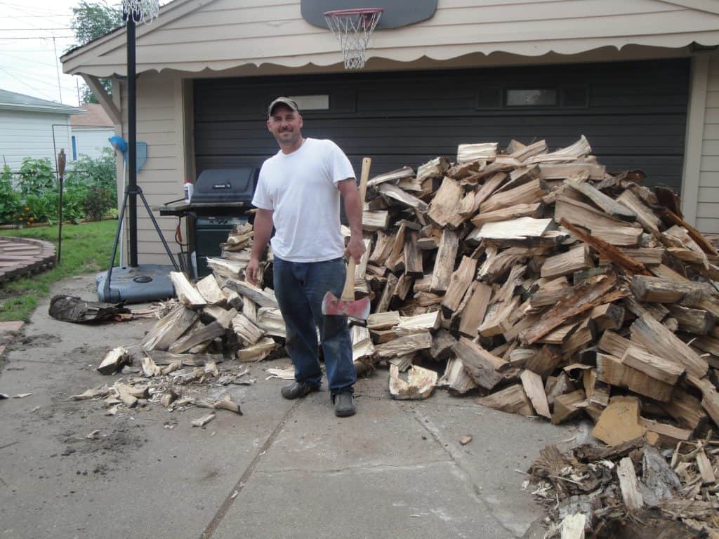 Man with a pile of cut wood.