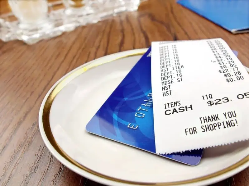 A dinner plate with credit card and bill on top.