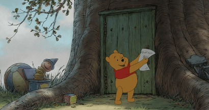 Winnie the Pooh holding a paper in the air.