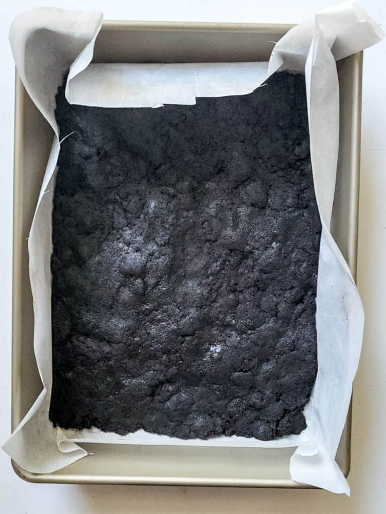 A dessert with mint chocolate chip ice cream served in a baking pan on a white surface.