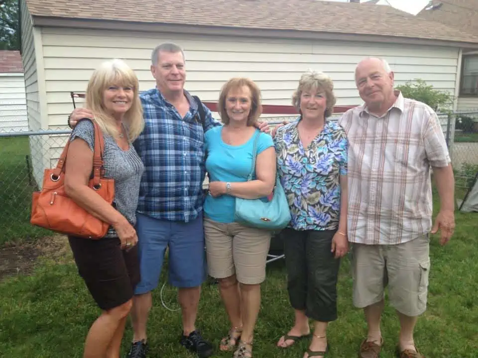 A group of people standing together smiling and having fun.