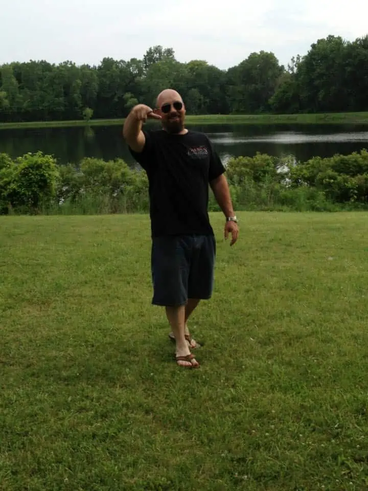 A man standing on top of a grass covered field