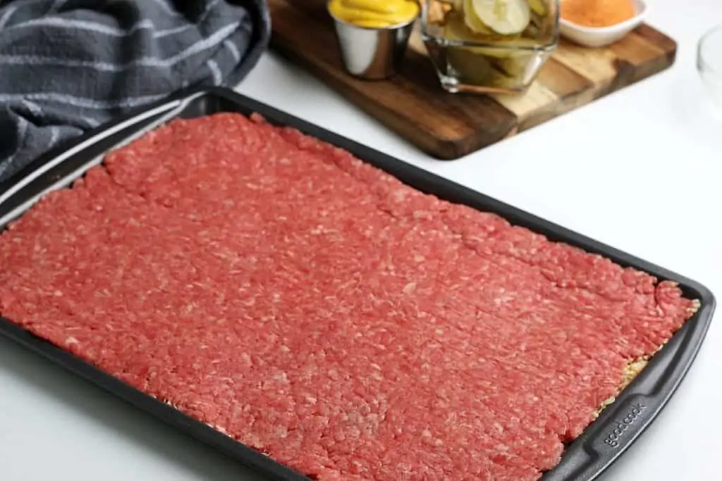 Smoothened ground beef in a cookie sheet pan.