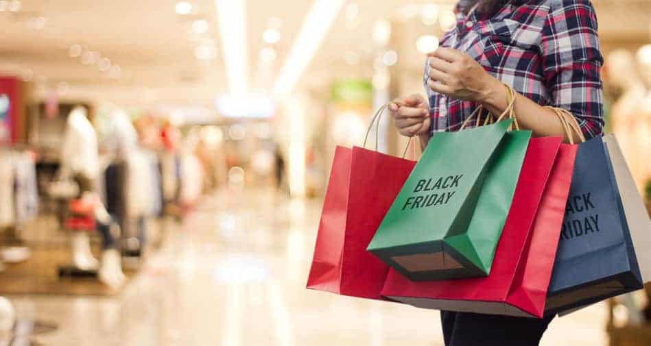 Black Friday, Woman holding many shopping bags while walking in the mall.