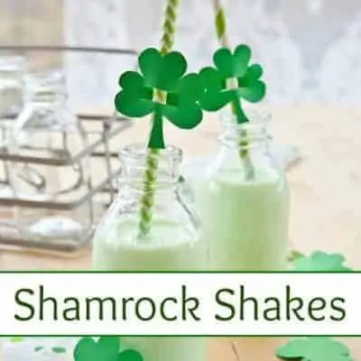 Shamrock Shakes in glass milk jars with green straws and green table cover.