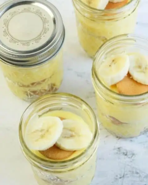 Close-up of a mason jar with banana pudding, nilla waffers, and sliced bananas.