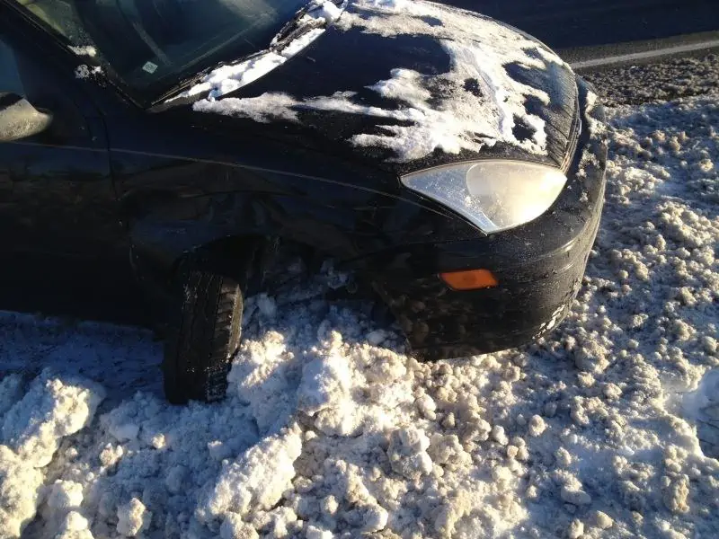 How to not drive in the snow. A car with a broken axel and tire popped out on the side.