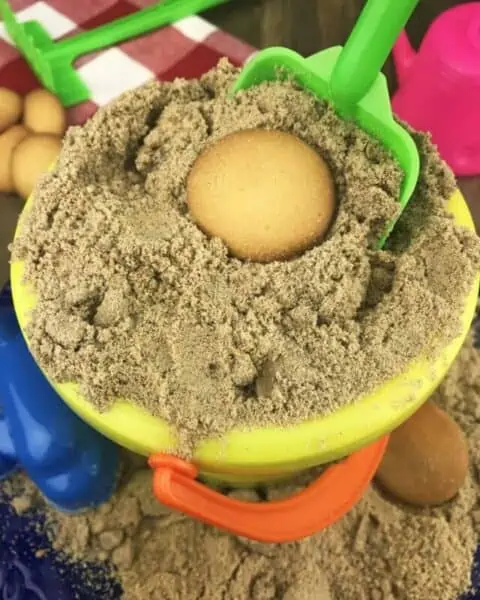 A yellow beach sand pail with pudding inside.