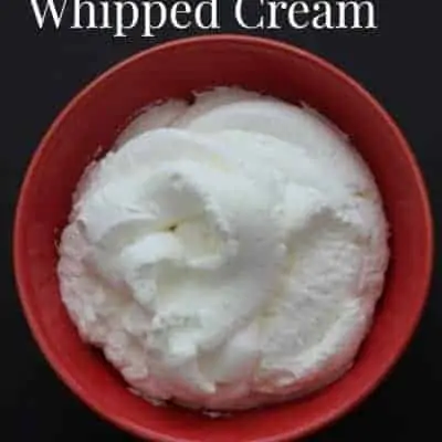 A red bowl of homemade whipped cream with only 2 ingredients.