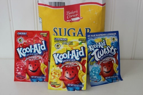 A bag of sugar and three packets of Kool-Aid drink mix