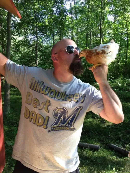 A man holding a chicken to his mouth