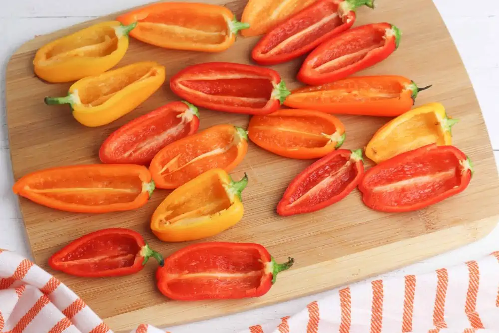Cut red, orange, and yellow peppers for stuffed mini peppers