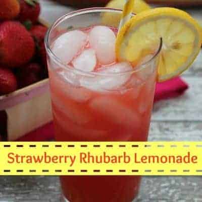 A glass full of strawberry rhubarb lemonade with lemon and ice.