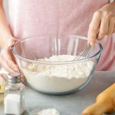 Woman making homemade food in order to save money on groceries with meal planning.