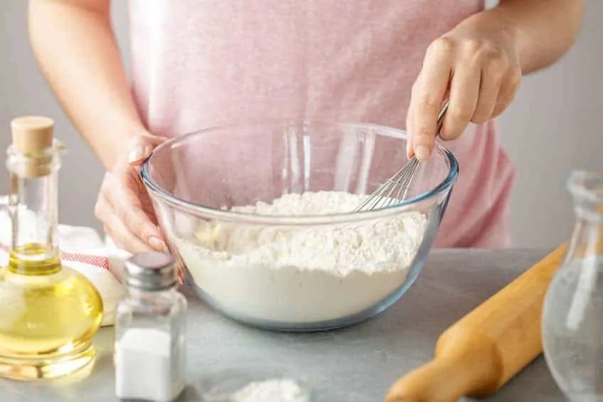 Woman making homemade food in order to save money on groceries with meal planning.