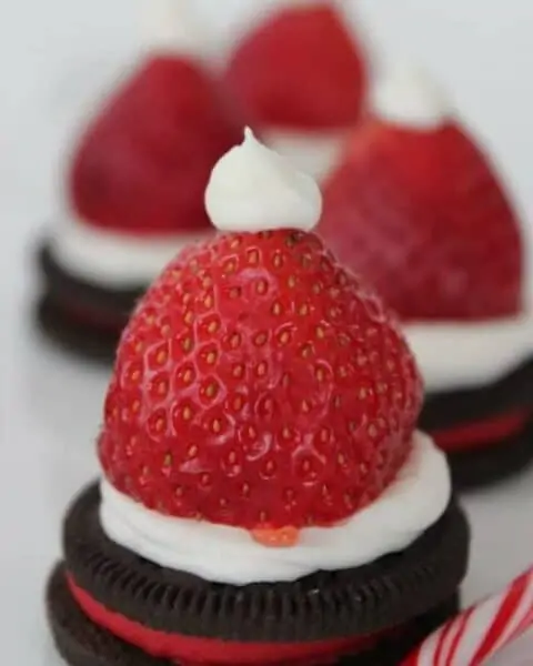 Oreo cookies with strawberry hats to make a Christmas Santa hat cookie.