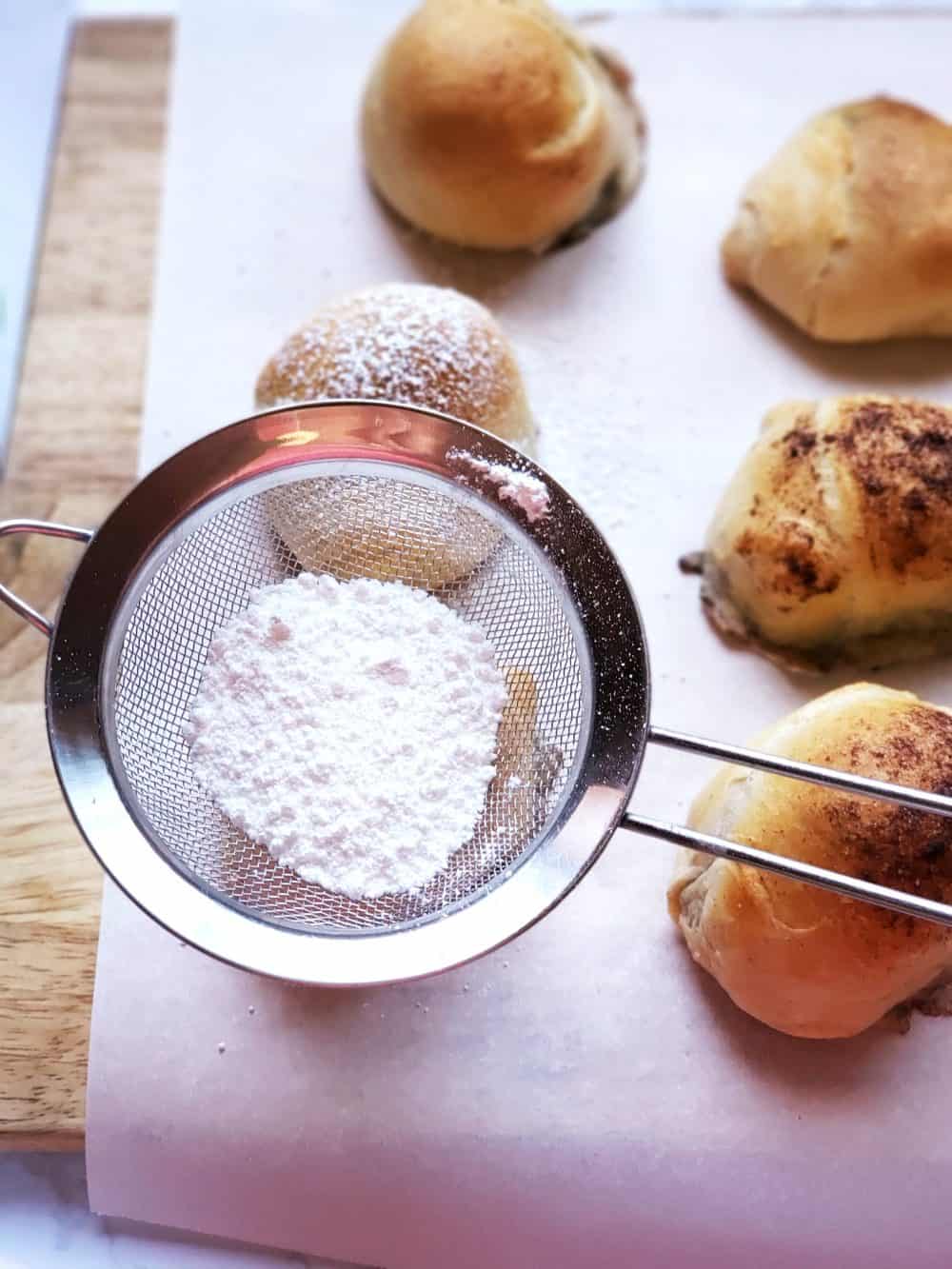 Drizzle powdered sugar on top of resurrection rolls.