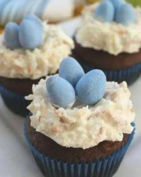 Chocolate cupcakes with coconut cream frosting and blue chocolate Cadbury eggs.