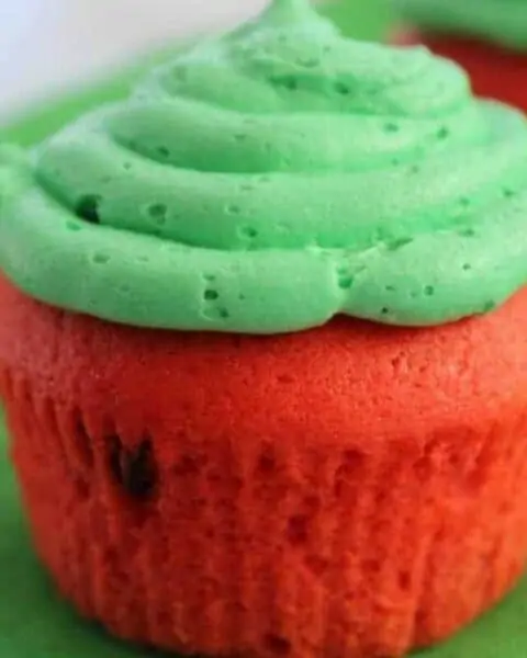 Watermelon cupcakes with green icing on top.
