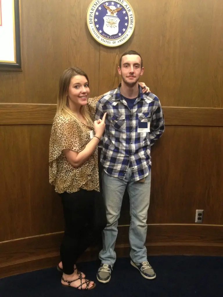 A young man standing next to his sister after his oath into the US military.