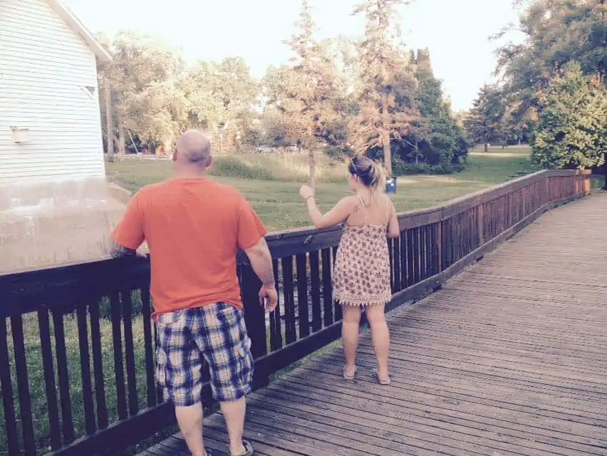 A man and a woman standing in front of a fence