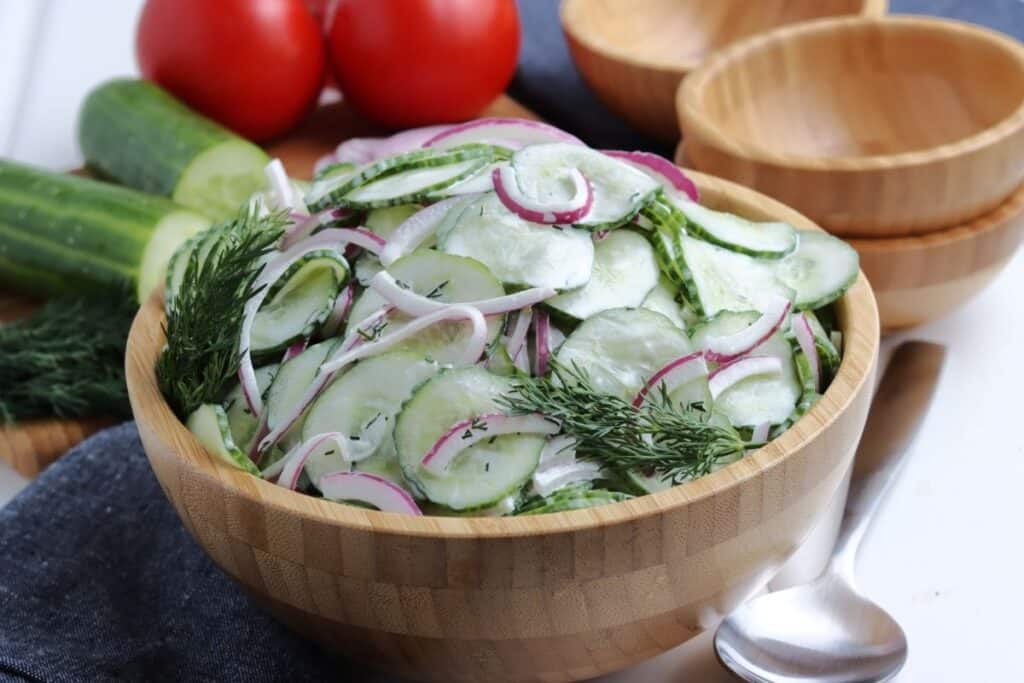 German cucumber salad in a bamboo bowl.