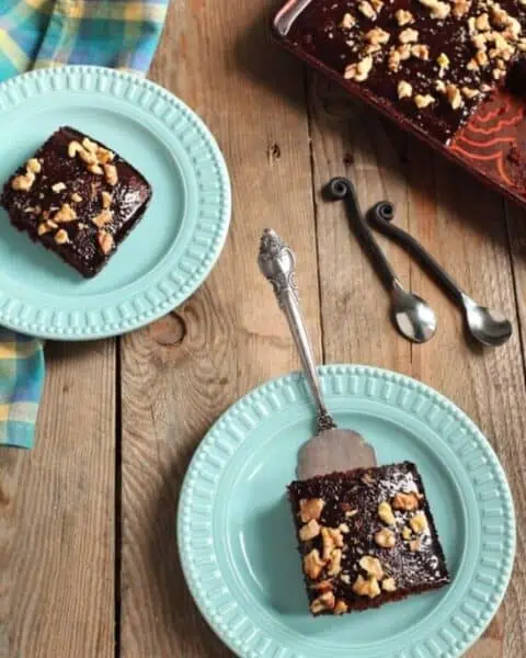 Chocolate brownie squares with walnuts garnished on top.