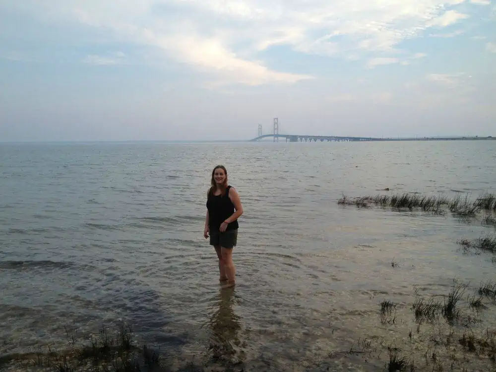 A woman standing on a beach near a body of water