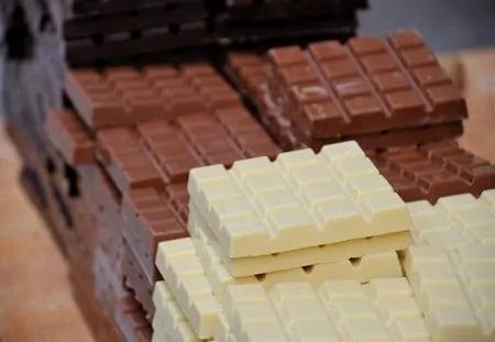 White chocolate bars and milk chocolate bars stacked on top of each other.