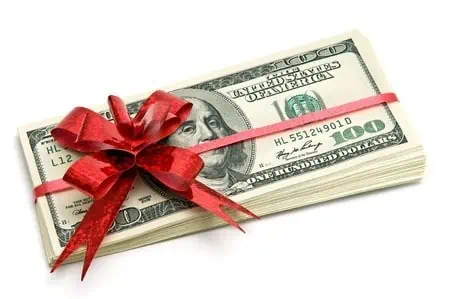 A stack of cash wrapped in a red Christmas bow. How to Earn Extra Cash for the Holidays