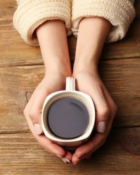A woman holding a cup of coffee in her hands.