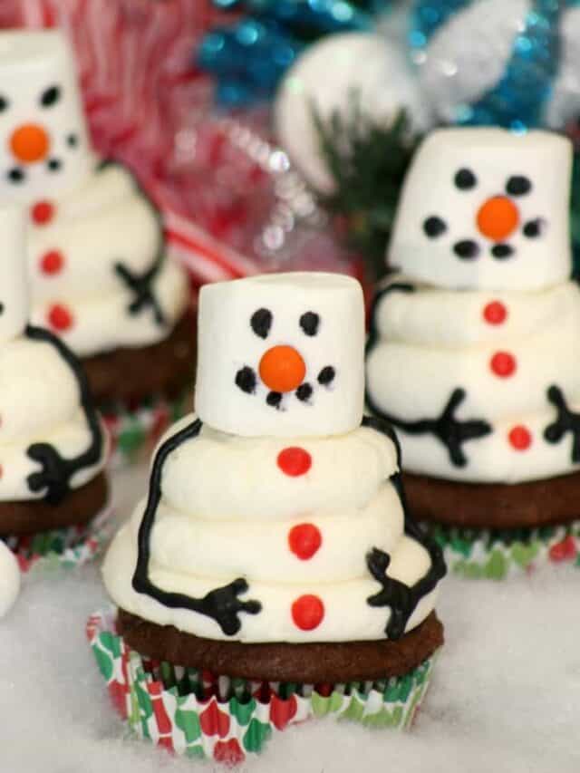 Snowman Cupcakes crowded together on the table top.