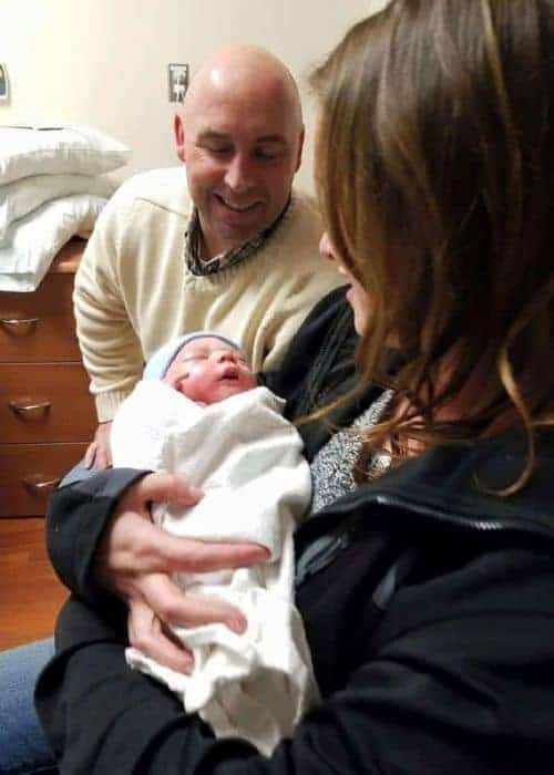 Grandparents holding a newborn baby.