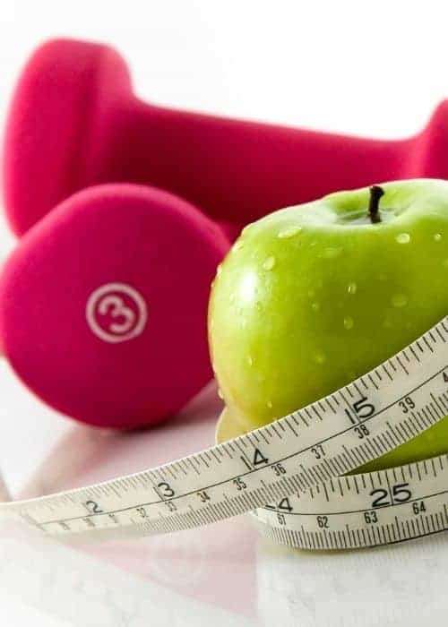 Pink tree pound weights and a green apple.