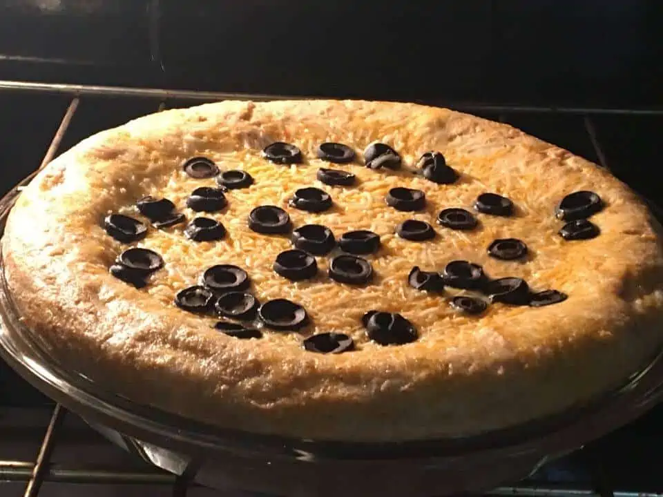 A pizza sitting on top of a pan on a stove top oven
