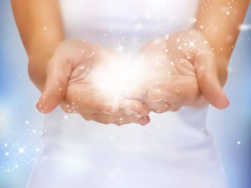 bright closeup picture of magic twinkles on female hands