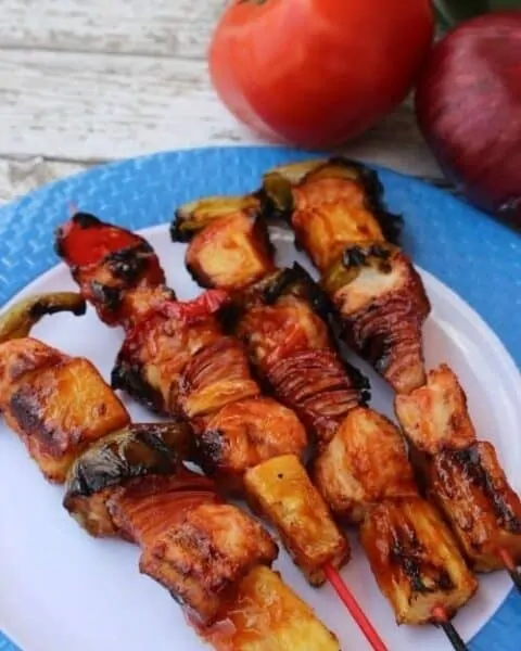 Grilled chicken and pineapple kabobs on a plate.