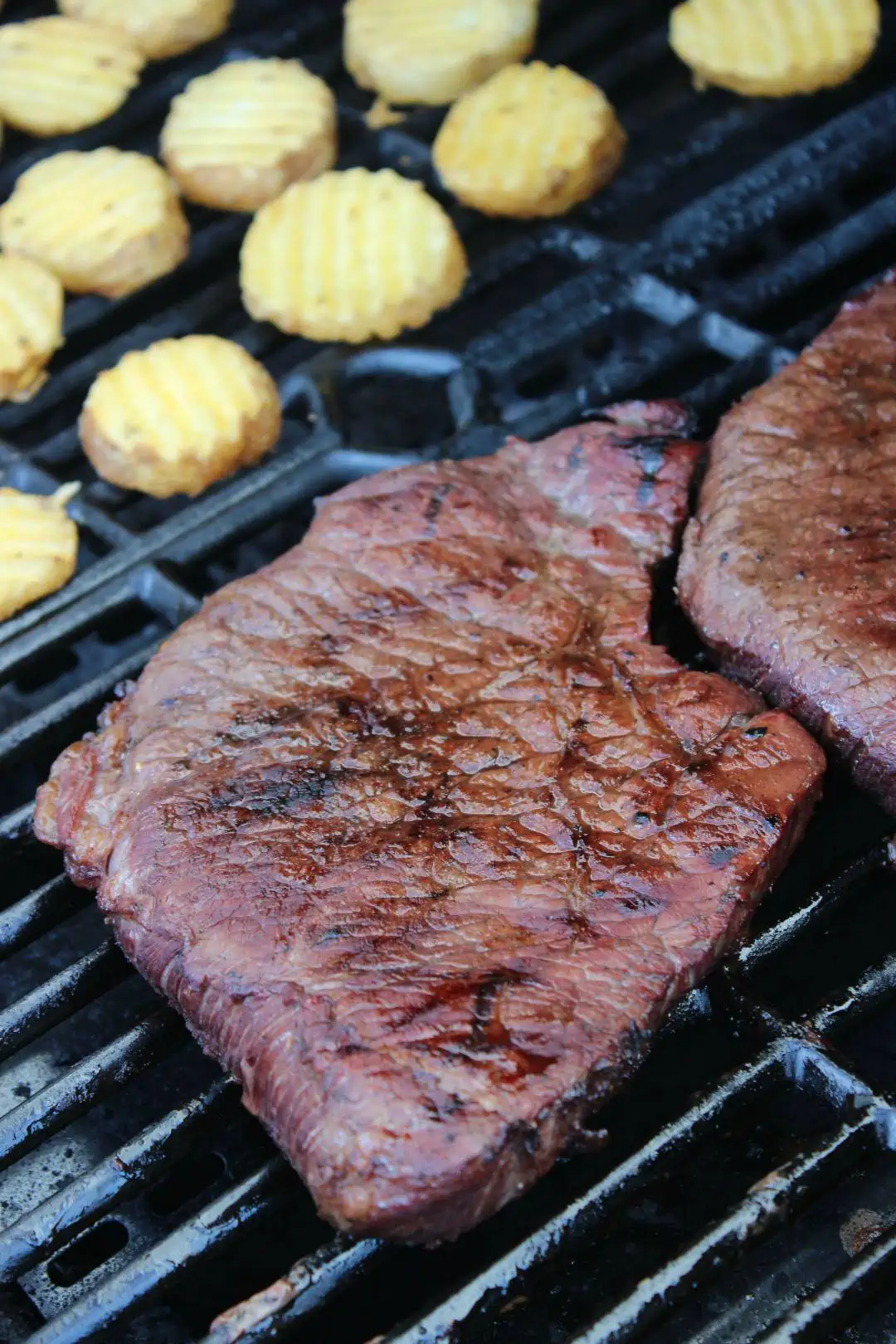 A close up of food on a grill, with London broil and Barbecue