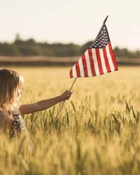A little girl holding an American flag.