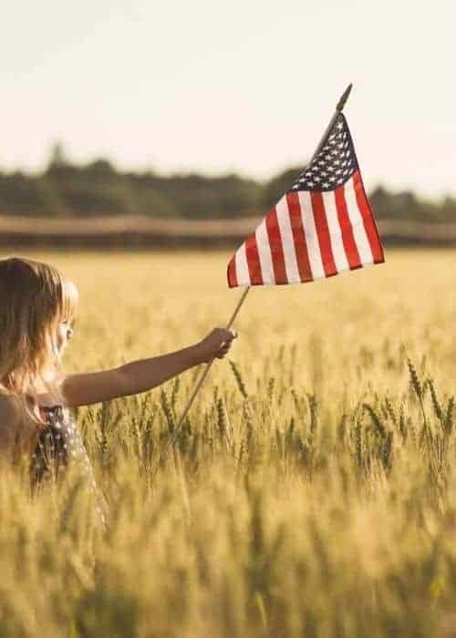 A little girl holding an American flag.
