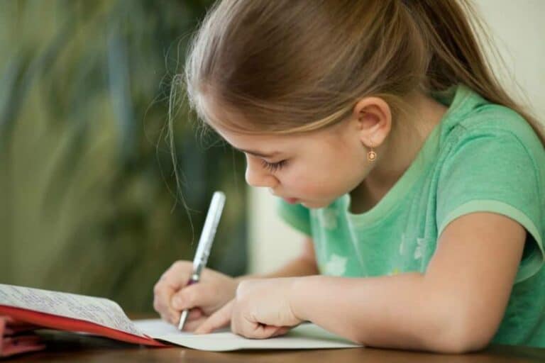 A little girl is writing a letter.