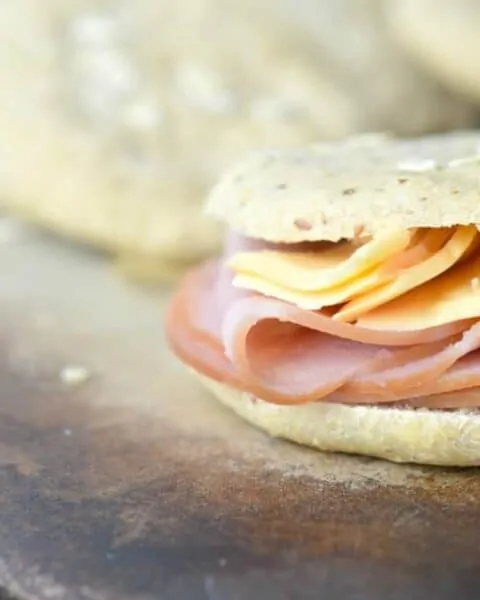 A close up of a Honey Whole Wheat Sandwich Thins with cheese and meat.