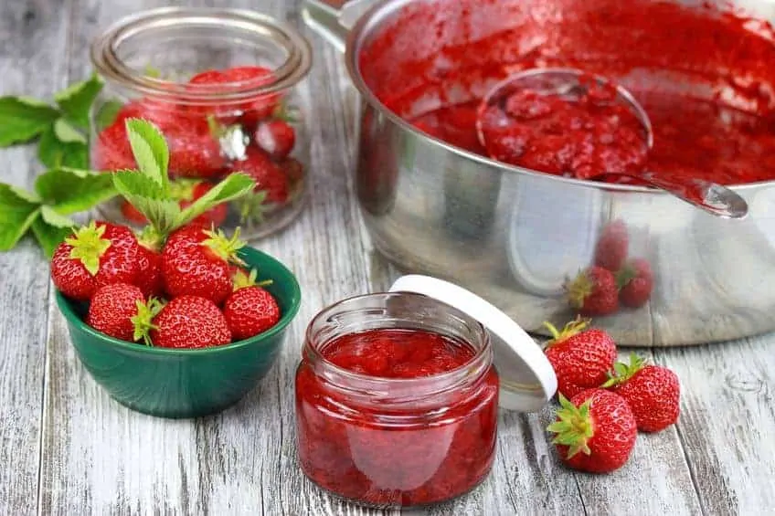  jar of tasty homemade strawberry preserve. strawberries harvest needed to preserve. homemade organic red strawberry jam.