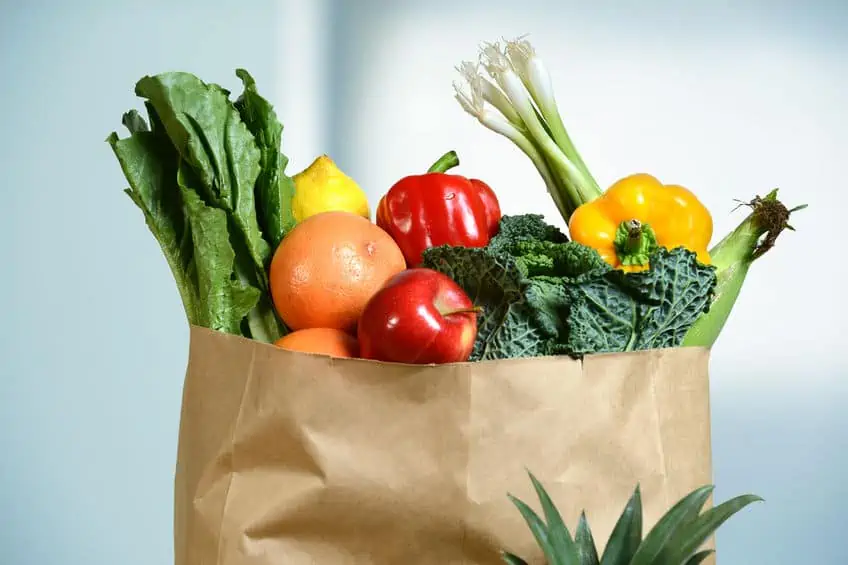 47647284 - assortment of fresh produce in grocery paper bag by window