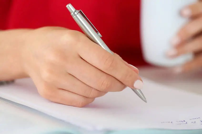 Woman writing Christmas list and planning for a Christmas party.