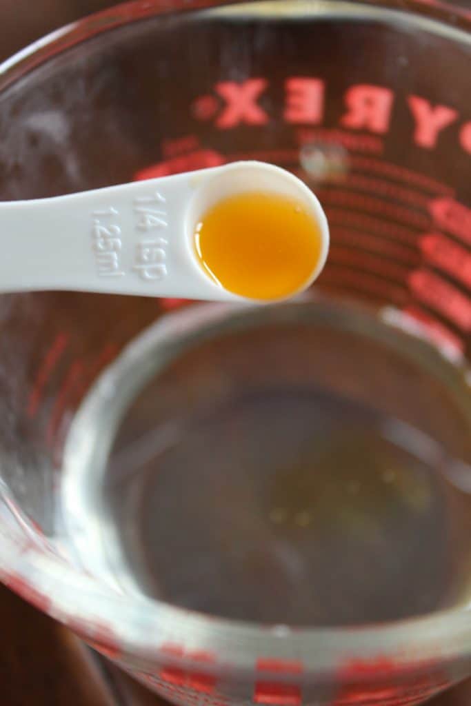 Vitamin e in liquid form being added to a bowl of coconut oil. 