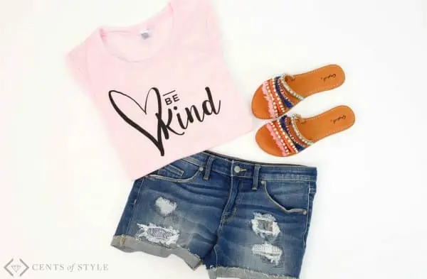 Pink \"Be Kind\" t-shirt and blue shorts.