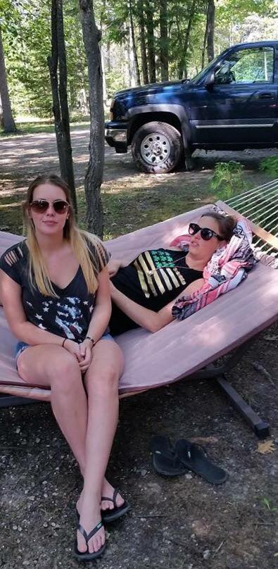 A woman sitting on a bench posing for the camera. How to Plan a Camping Trip