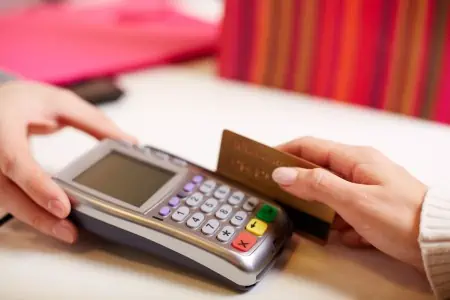 Swiping credit card while shopping.